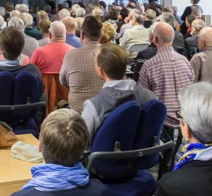 Menschen sitzen im Publikum in einer Veranstaltung