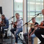 Vierköpfige Band mit Gitarre und anderen Instrumenten im Archivgebäude