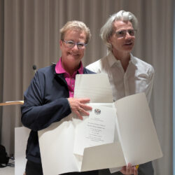 Bettina Schmidt-Czaia und Stefan Charles, sie hält die Entlassurkunde in der Hand