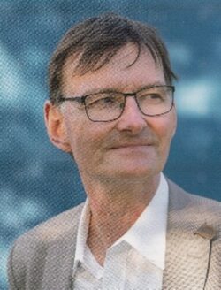 Porträtfoto Prof. Schwerhoff, heller Anzug, Brille, blauer Hintergrund