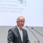 Vorsitzender Burkard von der MÜhlen am Rednerpult, hinten projiiziert das Logo der FREUNDE